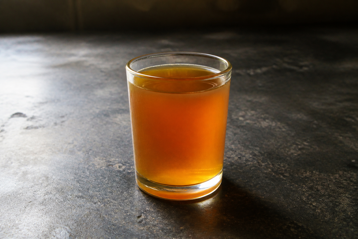 A glass of chilled mustard oil, the oil itself hazy rather than clear