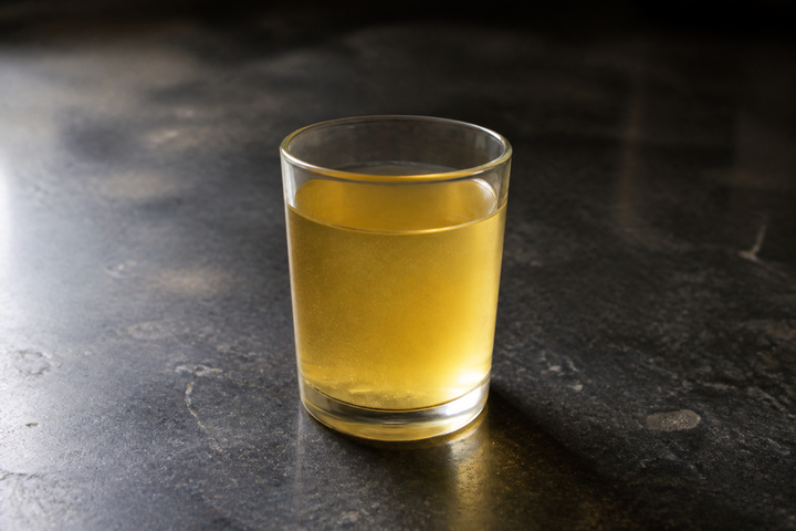 A glass of chilled groundnut oil showing a faint haze as it begins to thicken