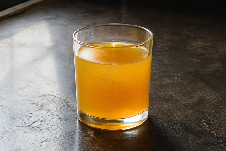 A glass of chilled yellow mustard oil, the oil itself hazy rather than clear