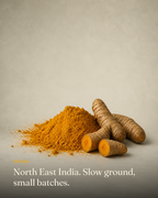Ground turmeric from North East India beside whole dried turmeric rhizomes, one snapped open